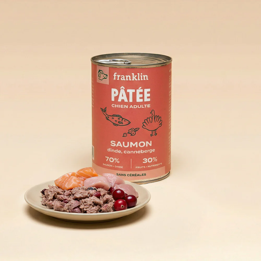 Boîte de pâtée Franklin saumon, dinde et canneberge, avec une assiette montrant la pâtée, du saumon et des canneberges